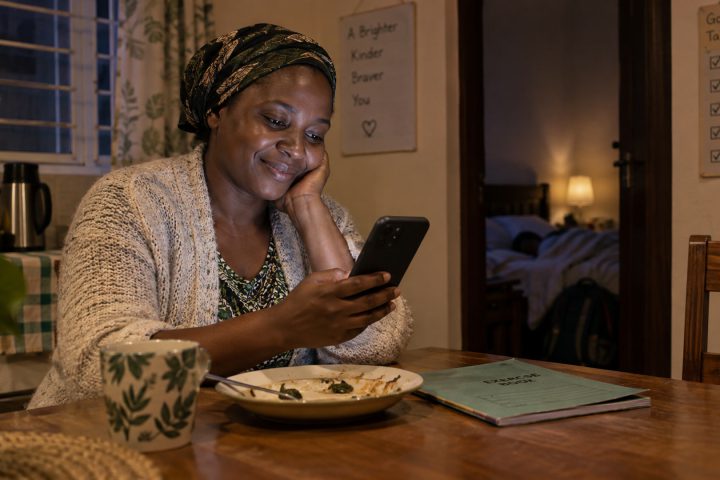 A parent checks a progress update on a phone after the child has gone to bed.