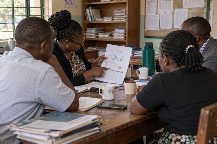 Teachers around a staffroom table with a printed insight report.