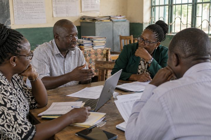 Adult headteachers in conversation at a modest county meeting, not a campaign stage.