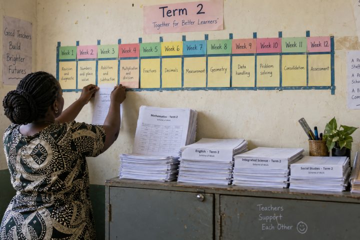 A handmade term planner and printed schemes on a staffroom cabinet.