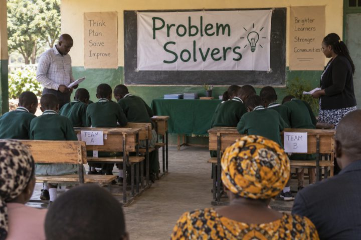 A modest school contest with learners at benches and teachers looking on.